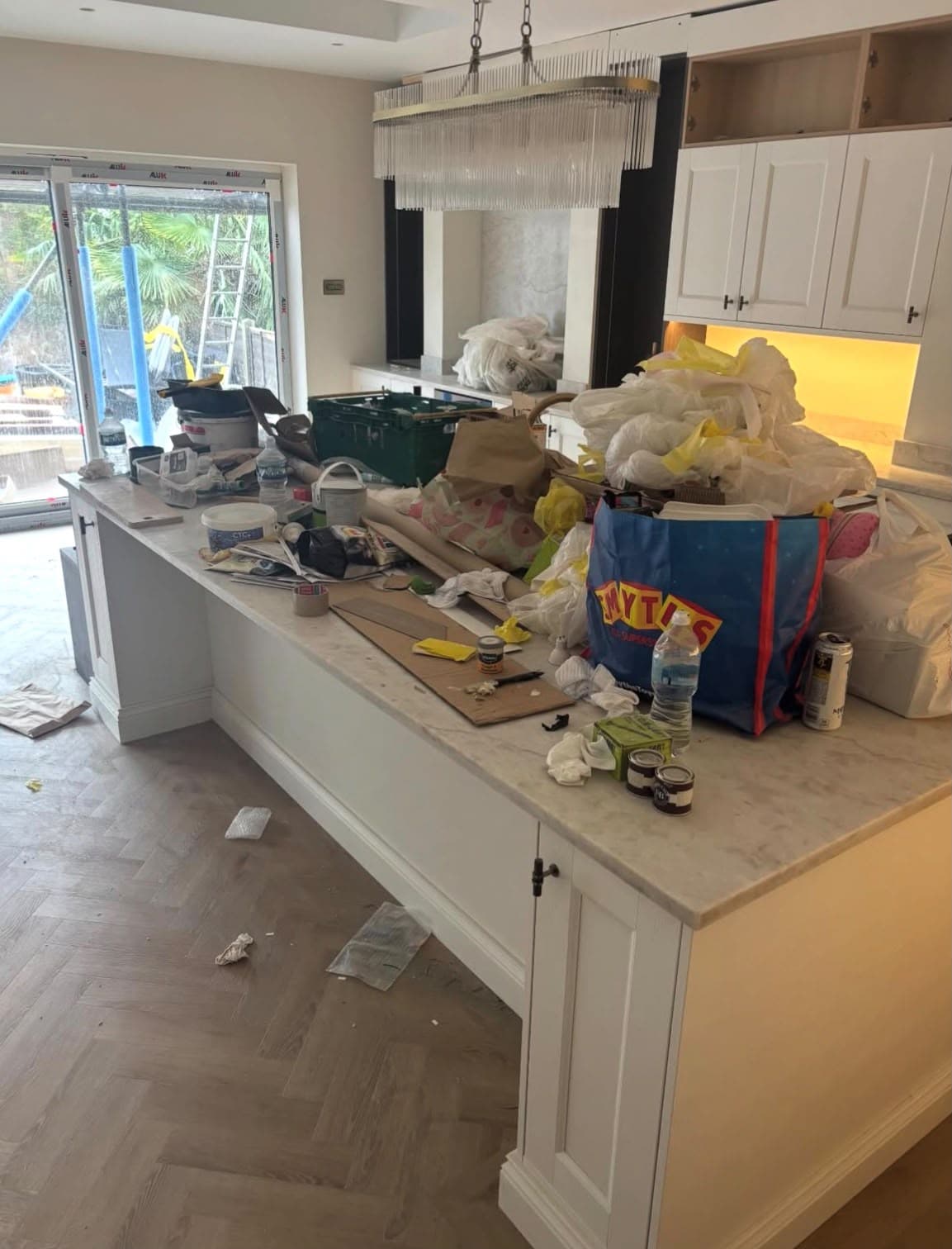 A kitchen mid-renovation, covered in building dust and debris